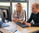 A member of area office staff assisting a customer at a computer screen